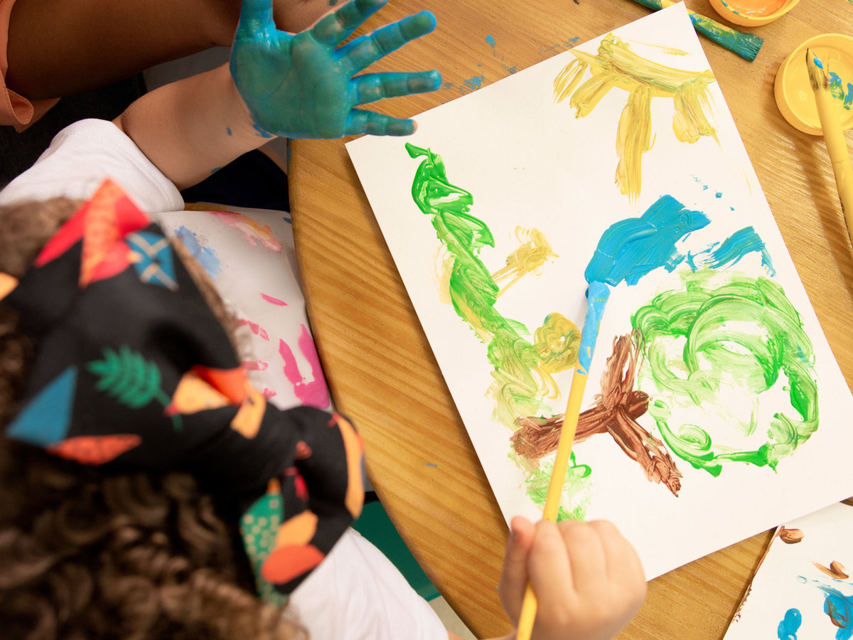 A child painting during a Kuddles learning activity