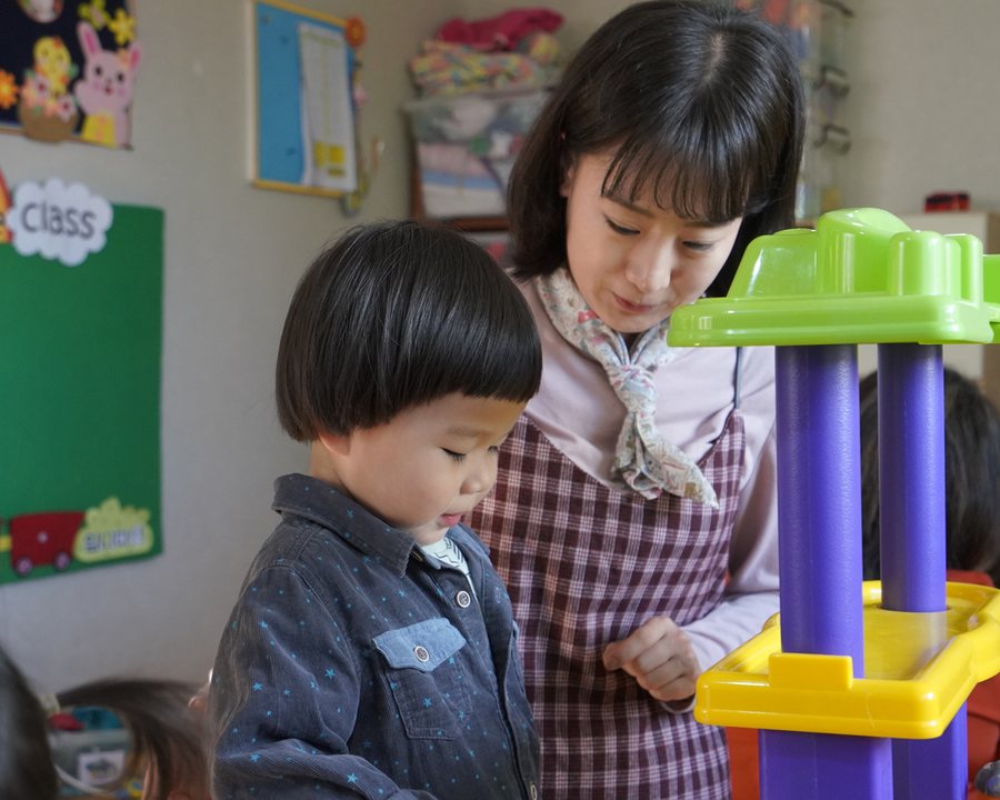 A child exploring colourful learning toys in a Kuddles home