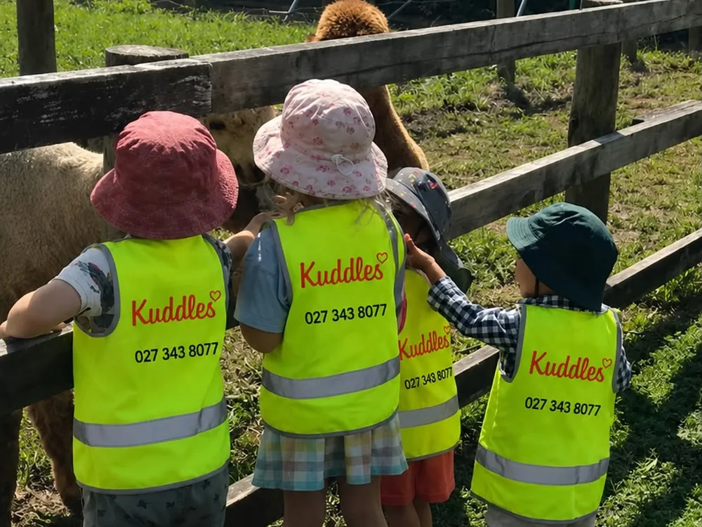 Kuddles children meeting alpacas on a farm visit
